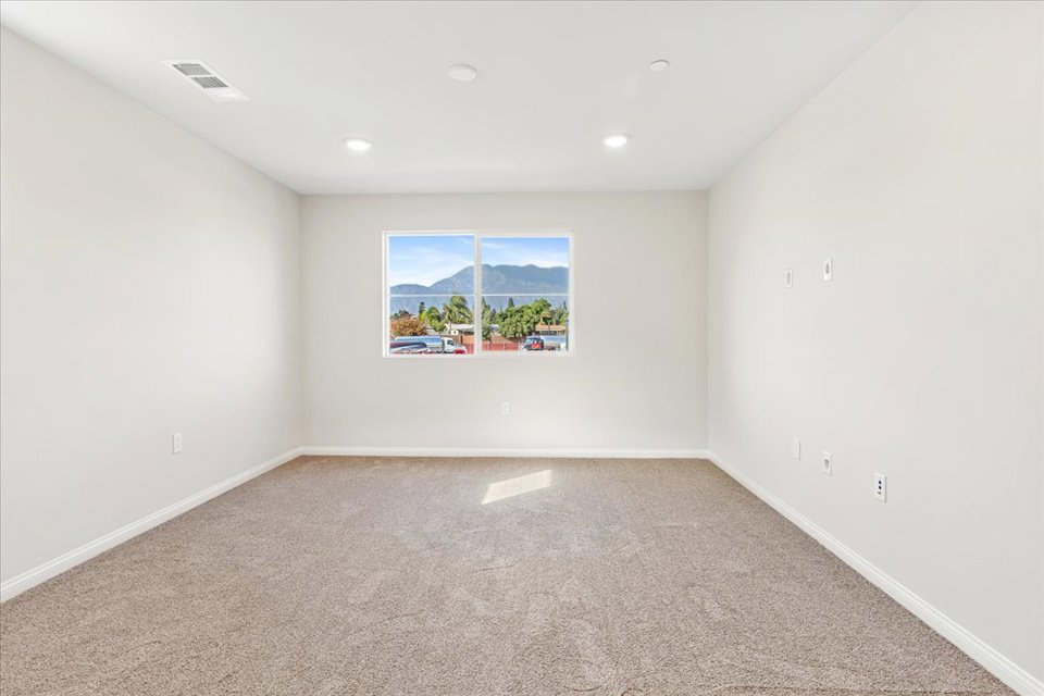 A room with a window and a painting on the wall.