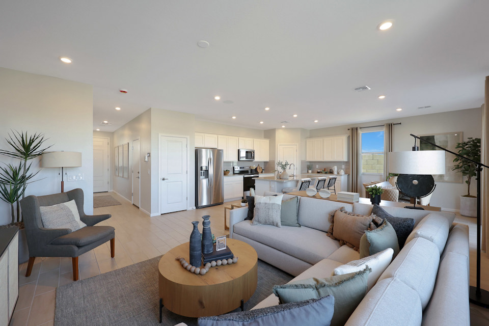 A living room with a large couch and a dining table.