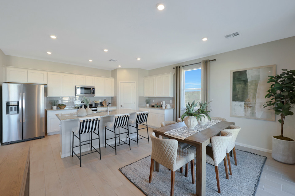 A kitchen with a dining table and chairs.