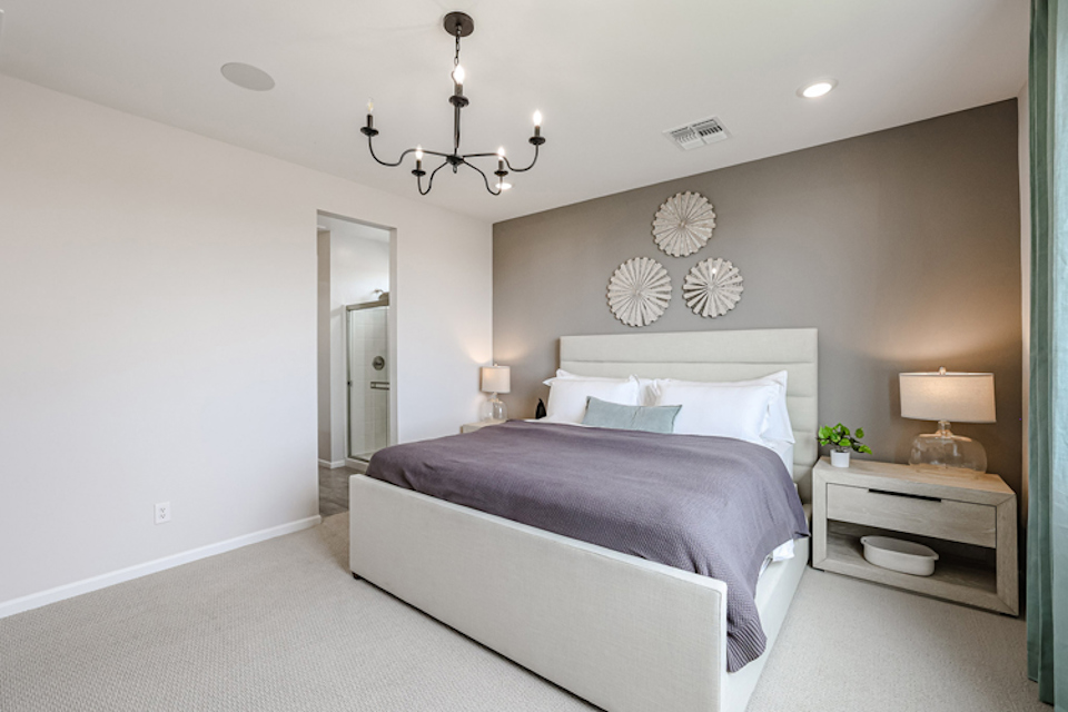 A bedroom with a bed and lamps.