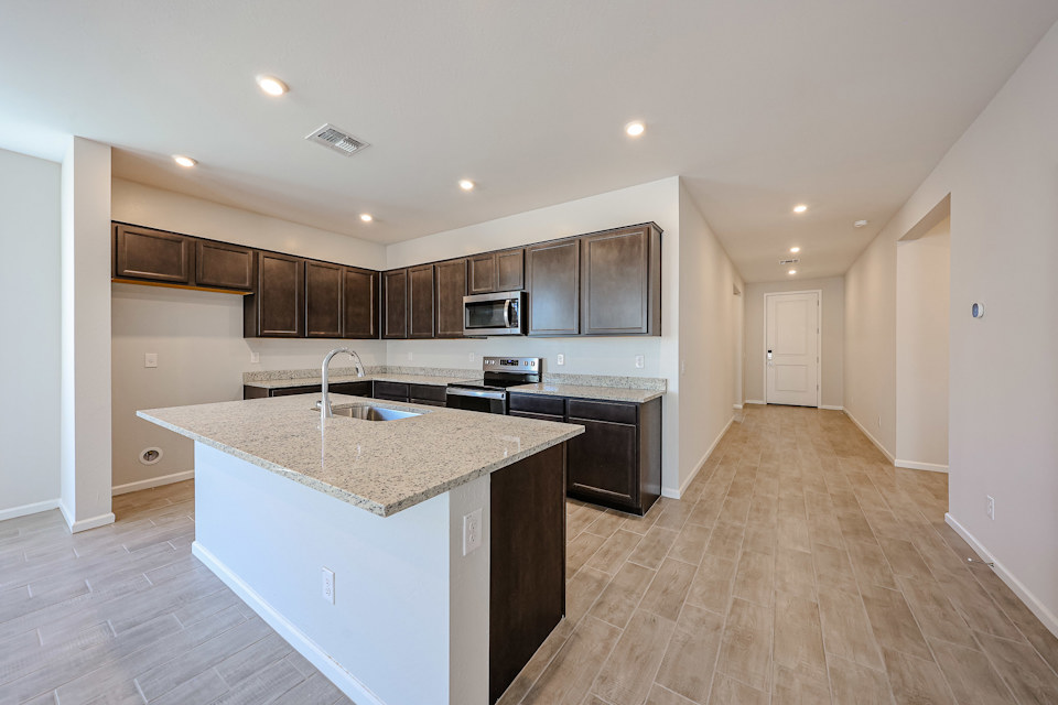 A kitchen with a marble counter top.