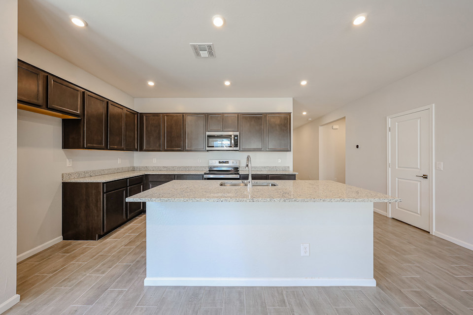 A kitchen with a marble counter top.