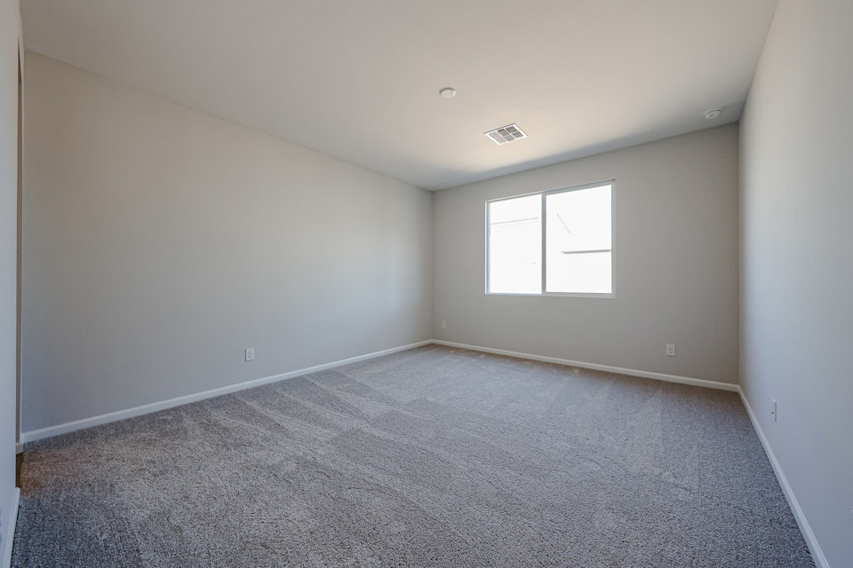 A room with a carpet and a window.