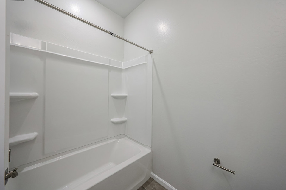 A bathroom with a shower unit and toilet.