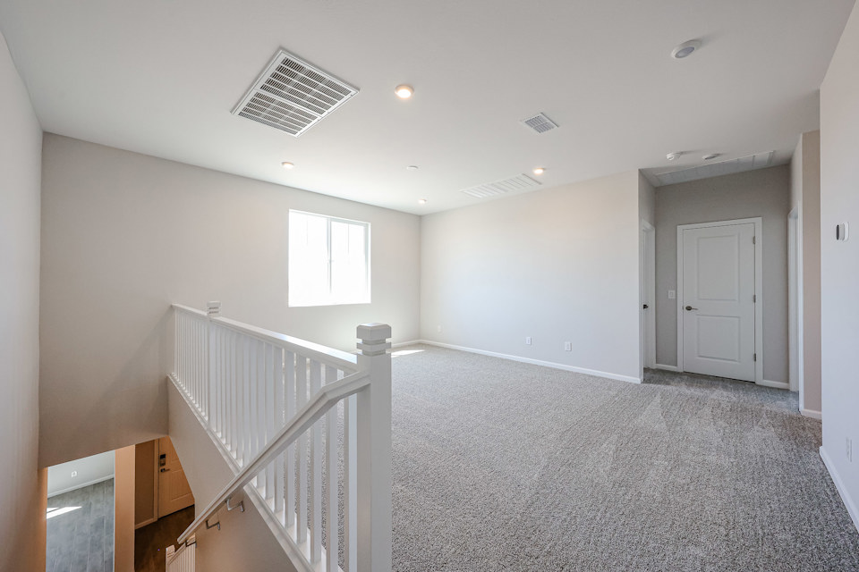 A room with white walls and a white railing.
