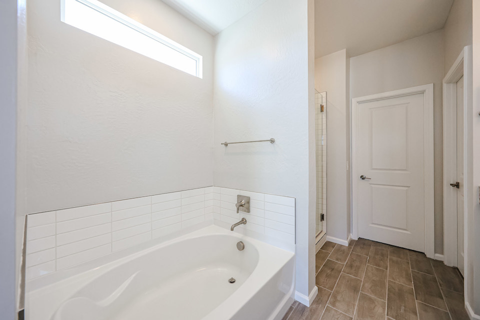 A bathroom with a tub and toilet.