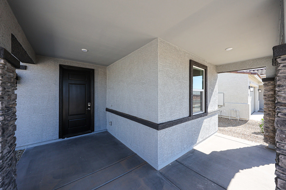 A stone wall with a black door.