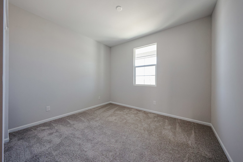 A room with a carpet and a window.