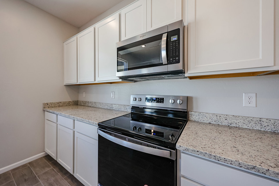 A kitchen with white cabinets.