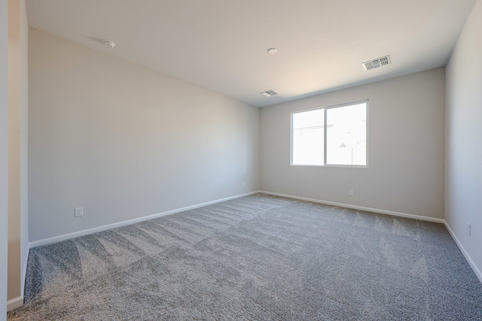 A room with a carpet and windows.