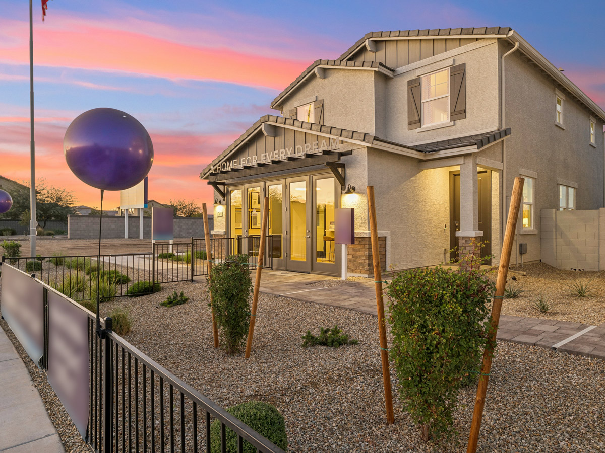 A house with a fence and a yard with a large balloon in the front.