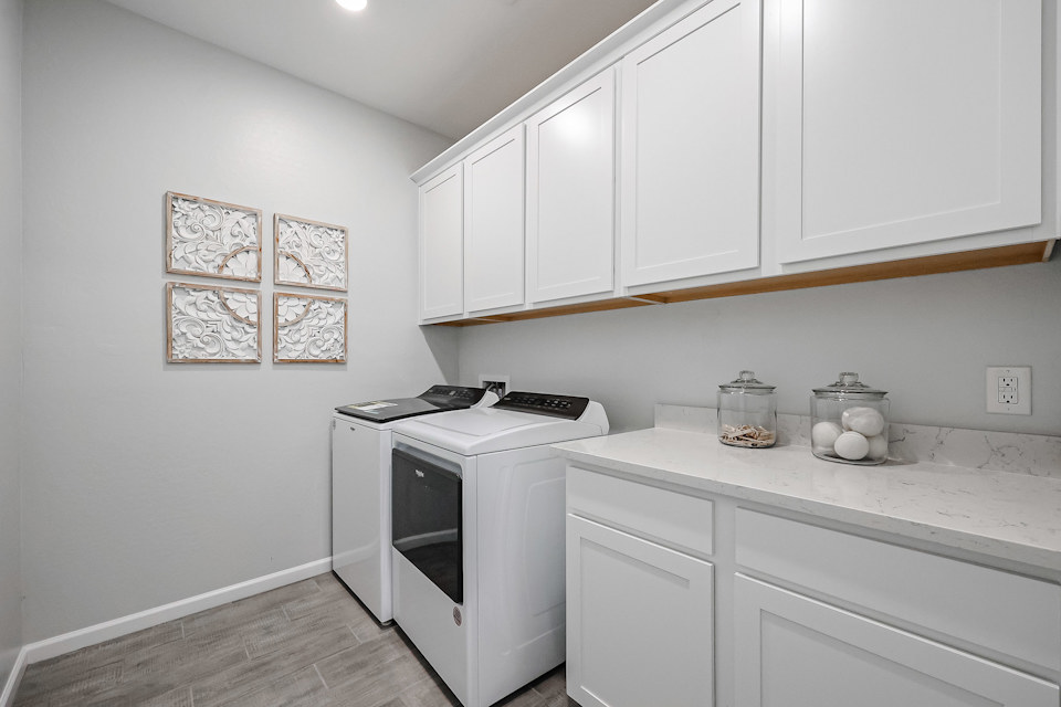 A kitchen with white cabinets.