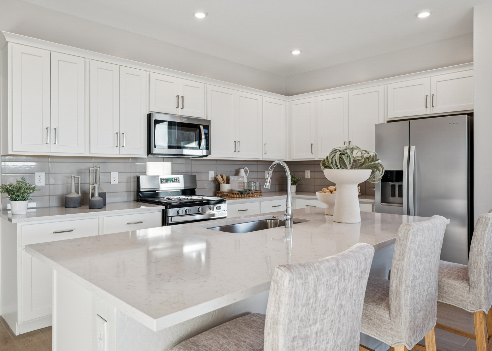 A kitchen with white cabinets.