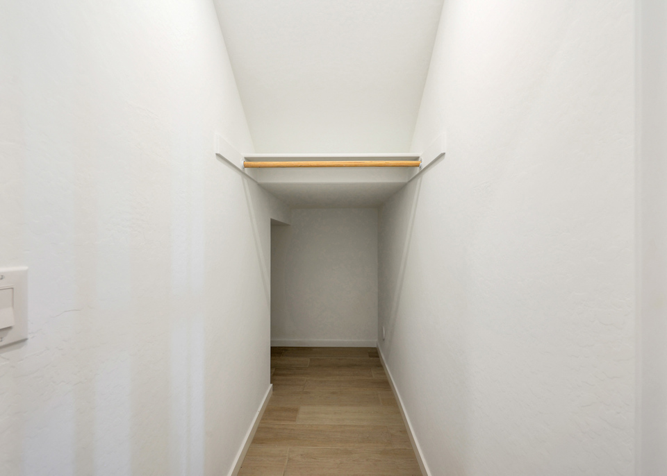 A white room with a wooden shelf.