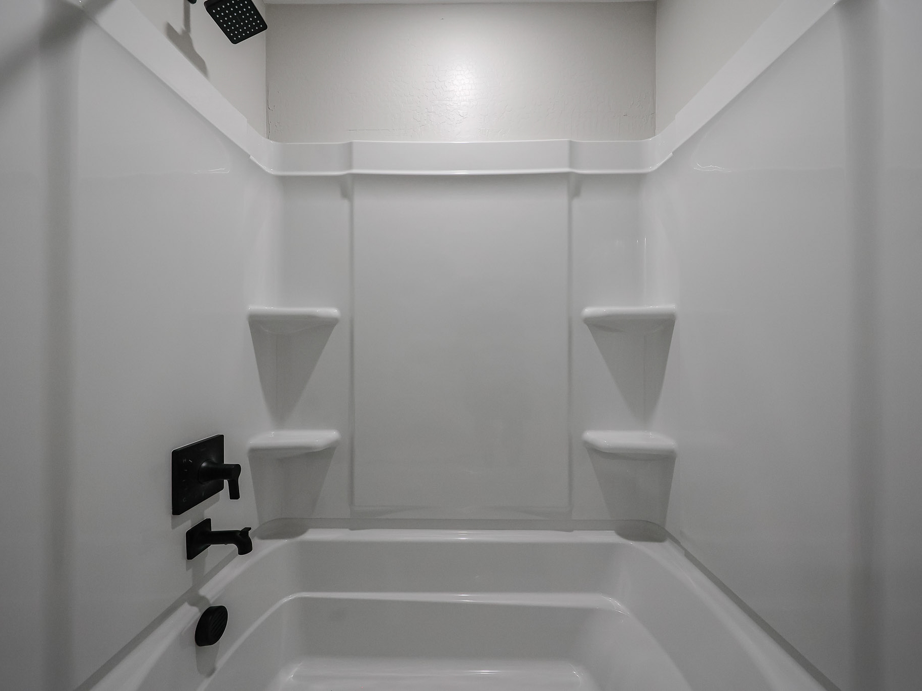 A bathroom with a tub toilet and urinal.
