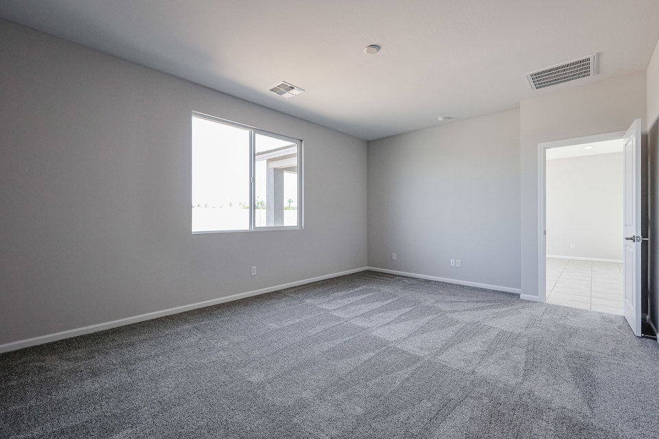 A room with a carpet and a window.