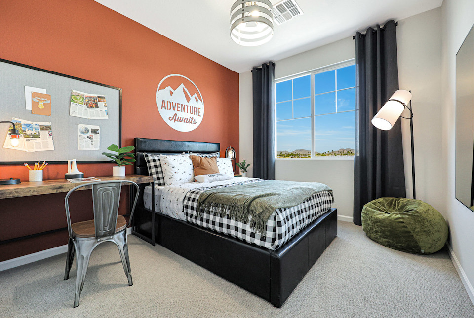 A bedroom with a bed and a desk.