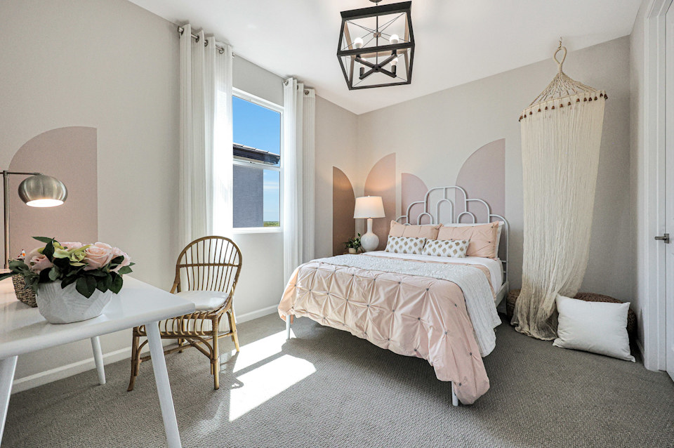 A bedroom with a bed and a table.