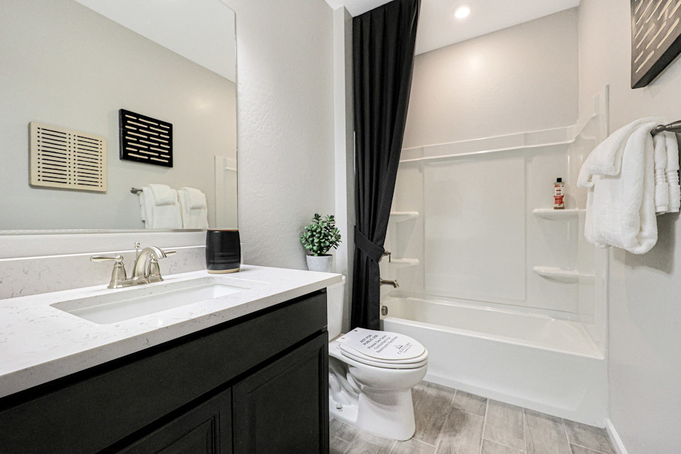 A bathroom with a tub sink and toilet.