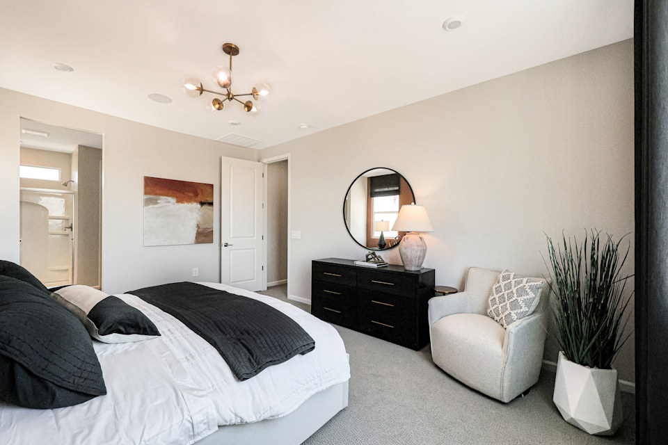 A bedroom with a bed and a chair.