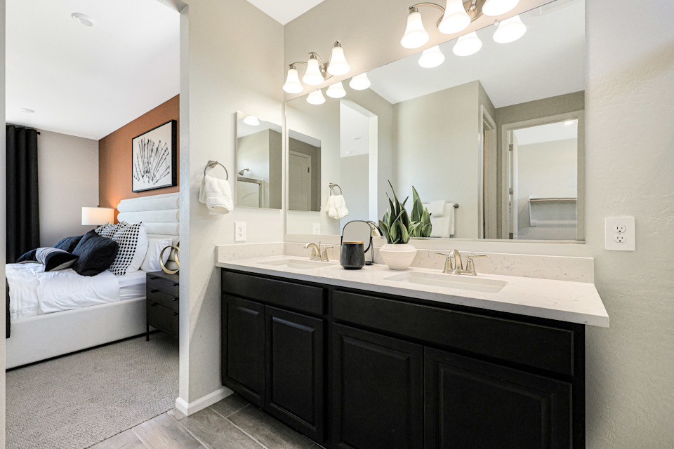 A bathroom with a sink and a bed.