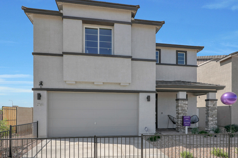 A white building with a black fence.