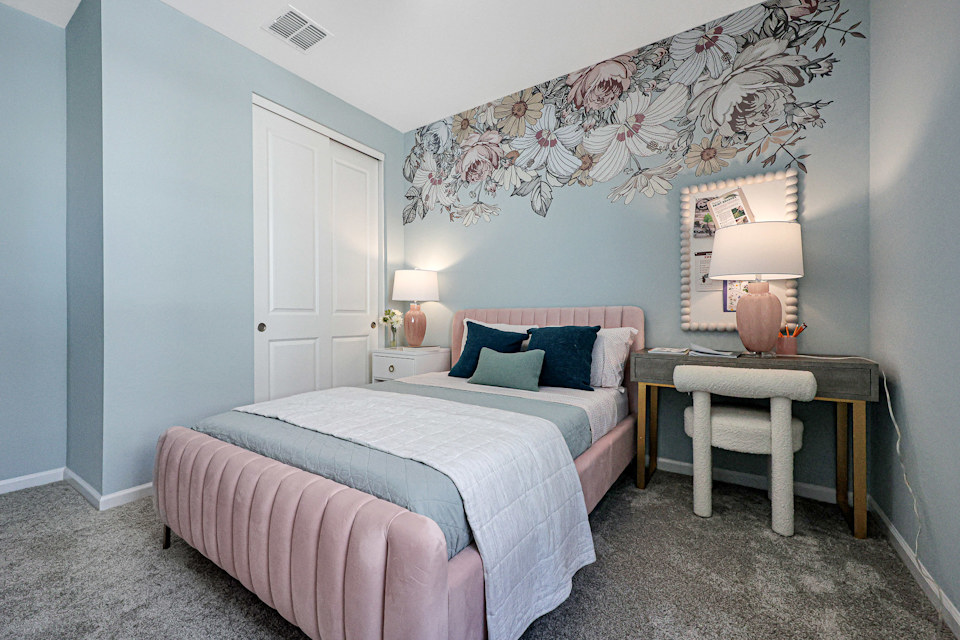 A bedroom with a bed and a desk.