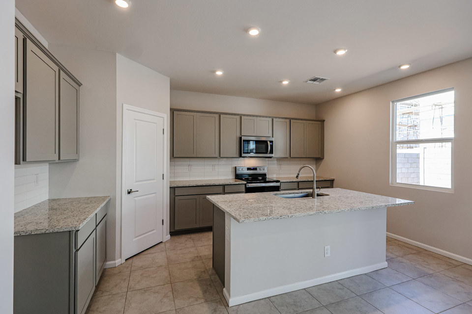 A kitchen with white cabinets.