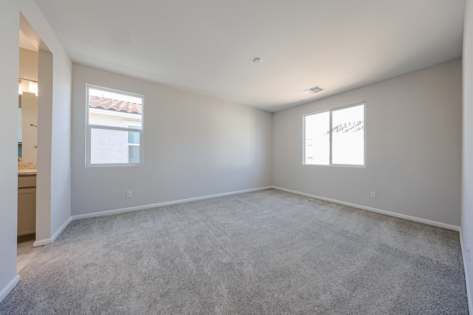 A room with a carpet and windows.