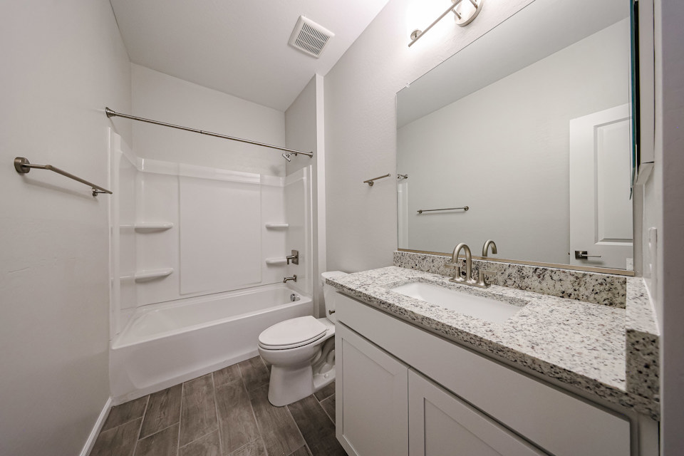 A bathroom with a tub sink and toilet.