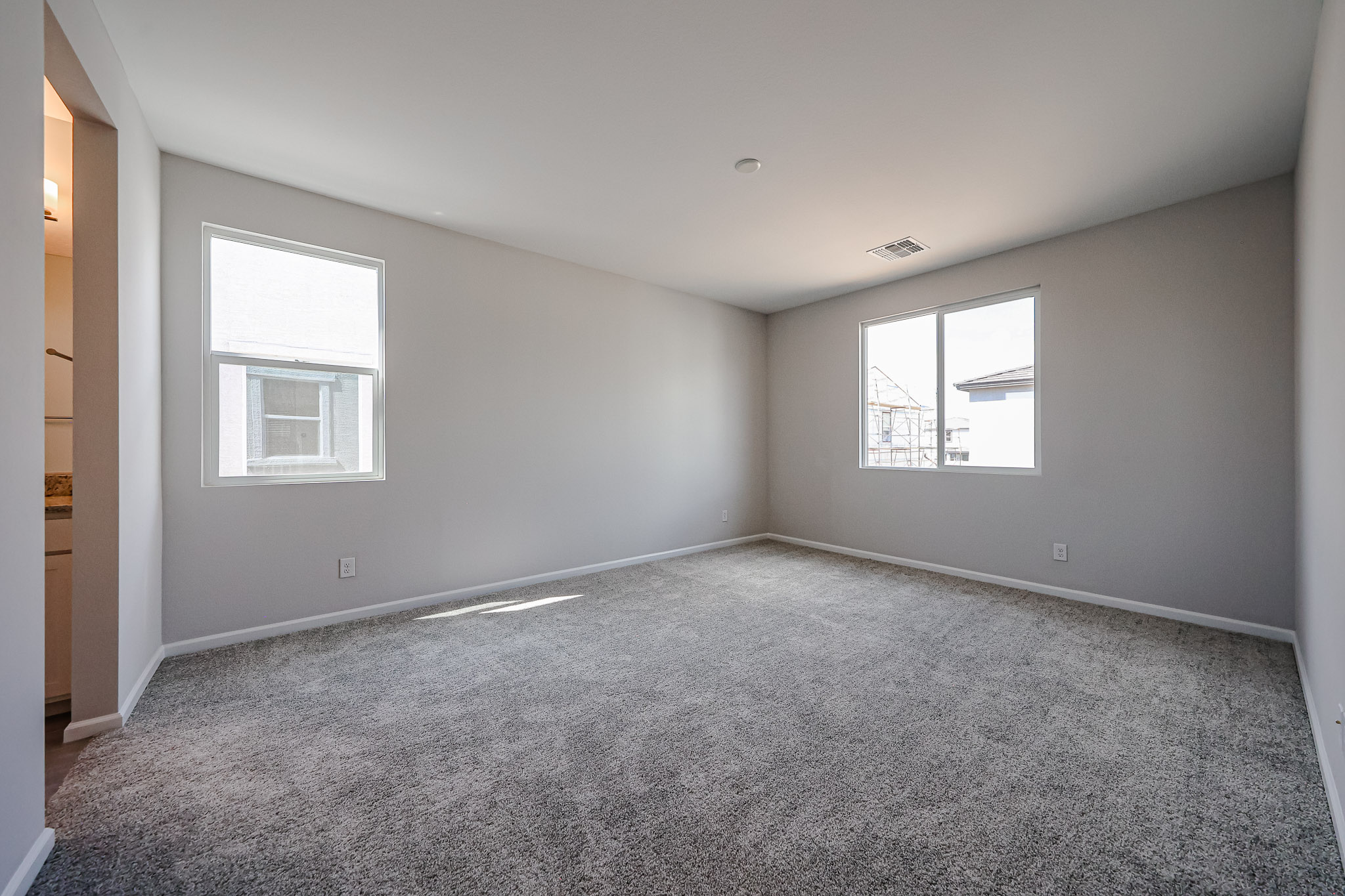A room with a carpet and windows.