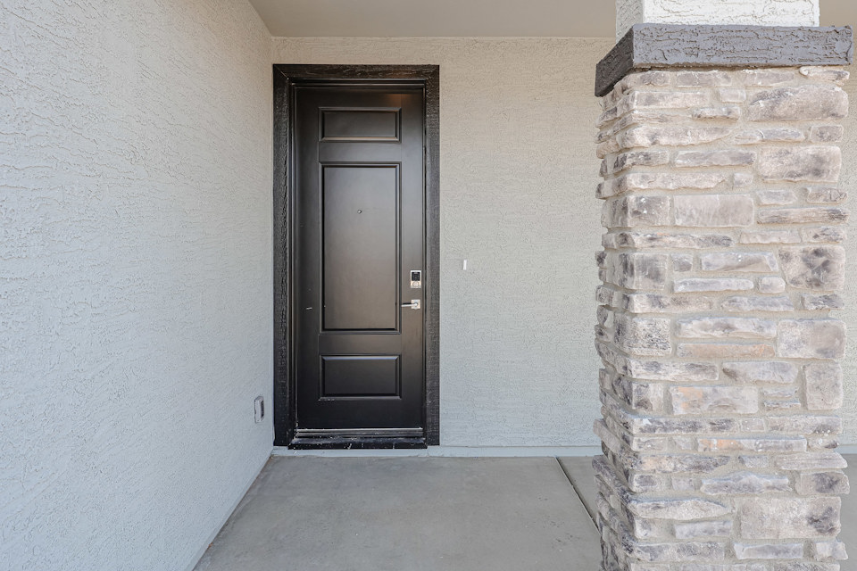 A black door in a stone wall.