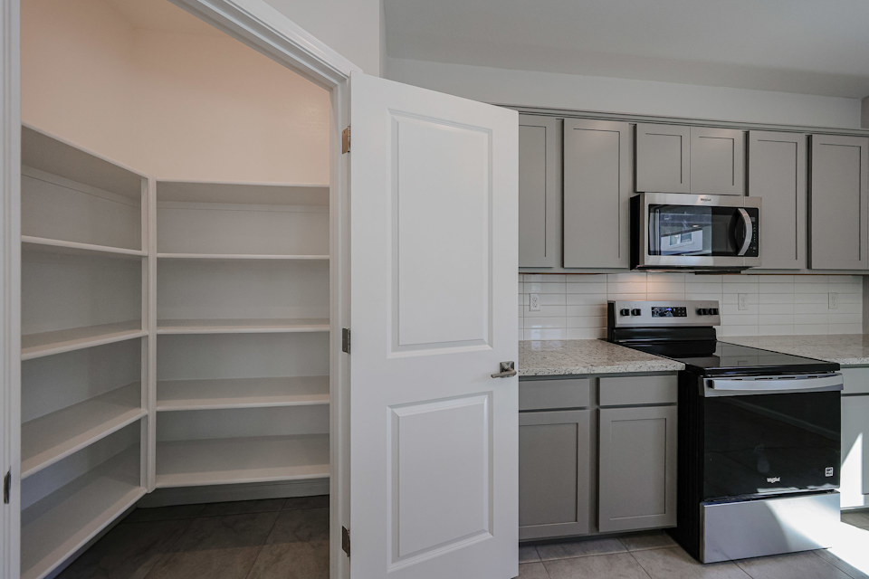 A kitchen with white cabinets.