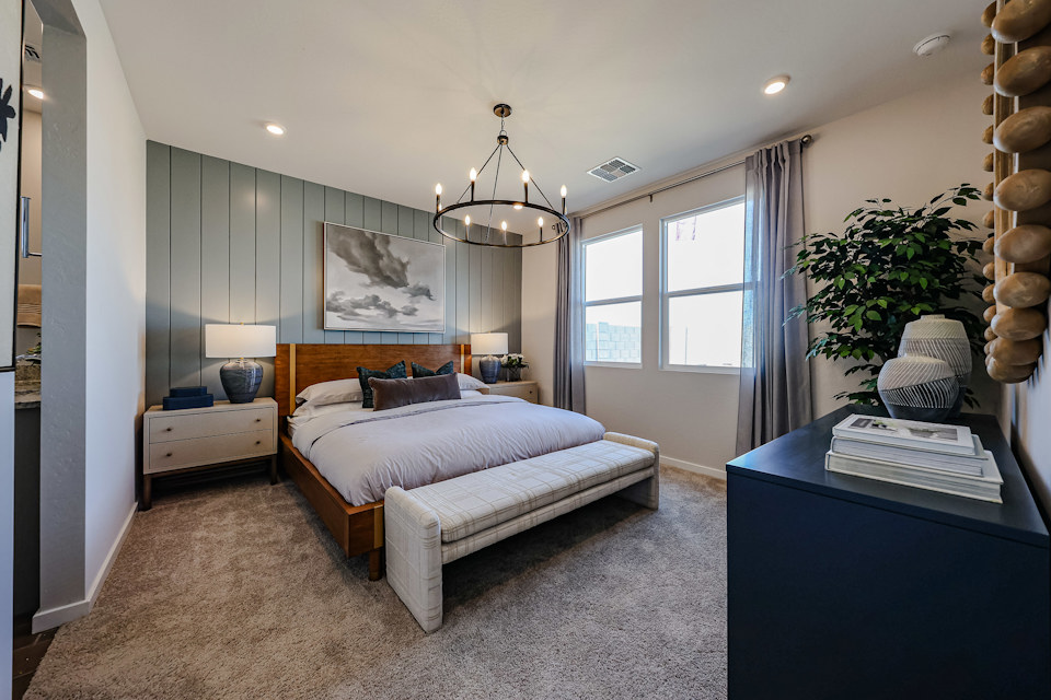 A bedroom with a bed and a plant.