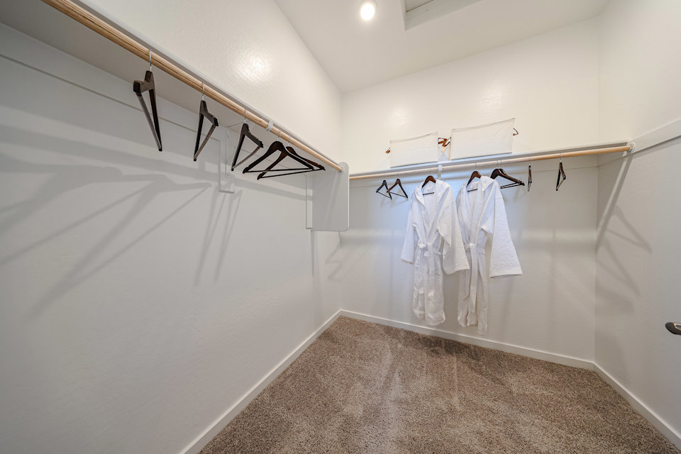A row of white clothes on a white wall.