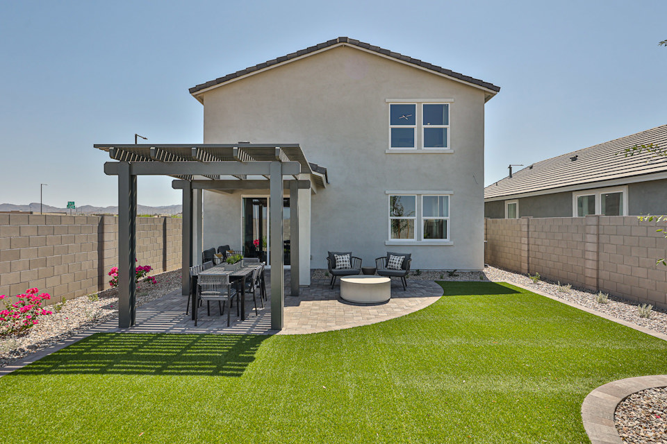 A house with a yard and a table and chairs.