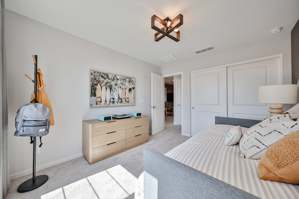 A bedroom with a bed and a lamp.