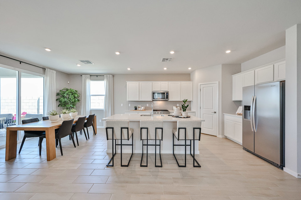 A kitchen with a table and chairs.