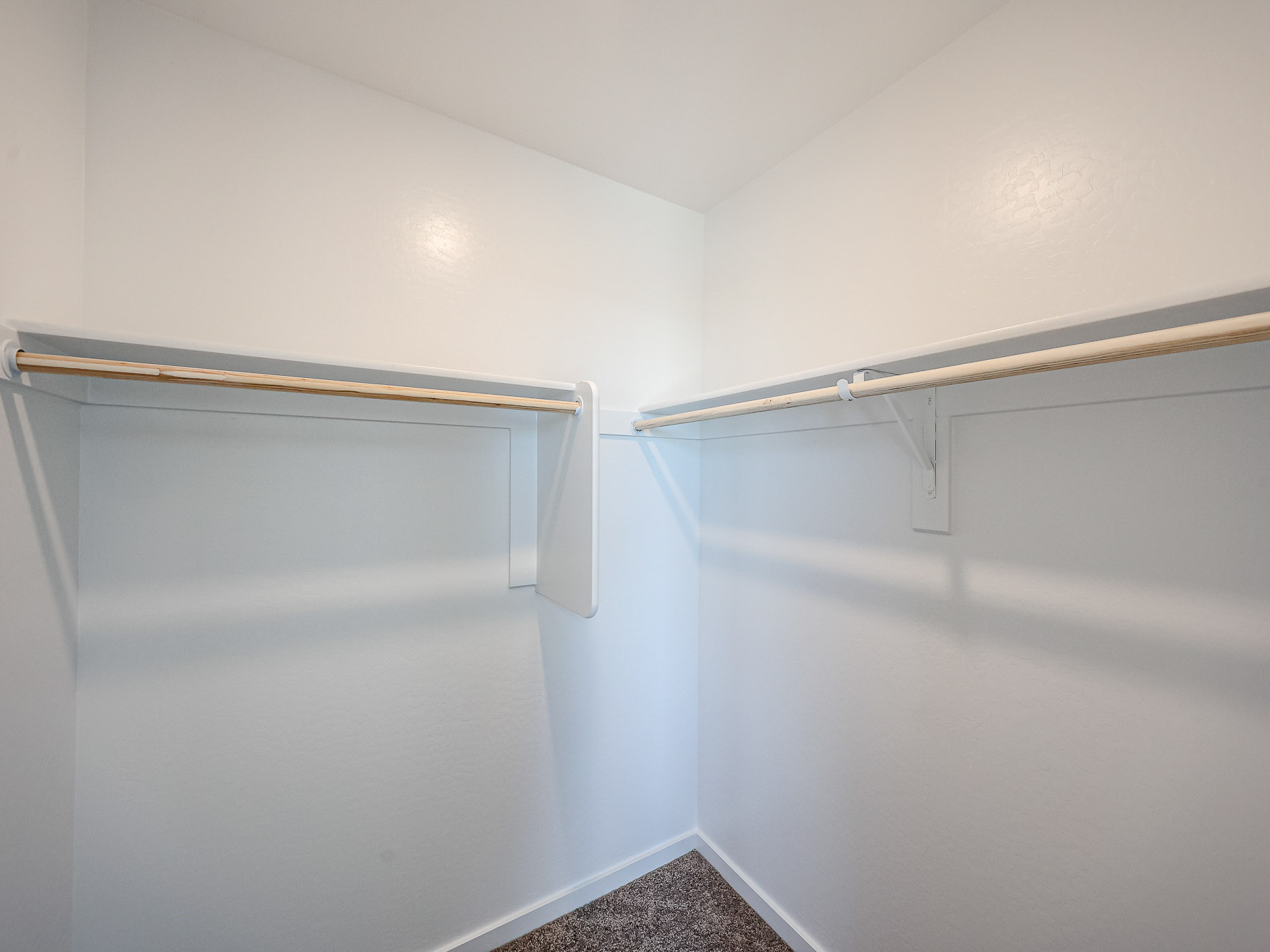 A white wall with a metal bar.