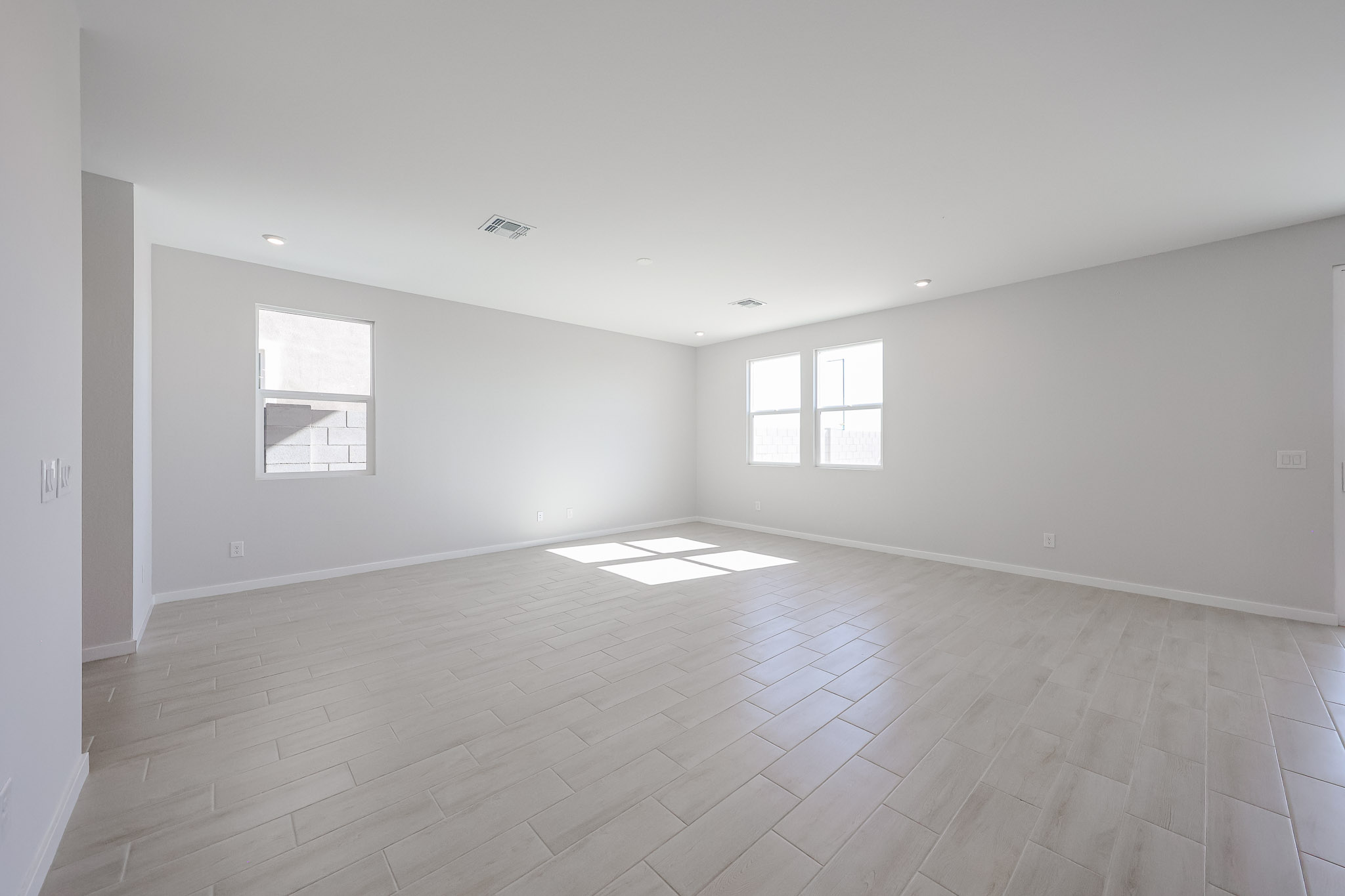 A room with a wood floor and windows.