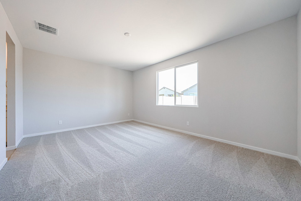 A room with a carpet and a window.