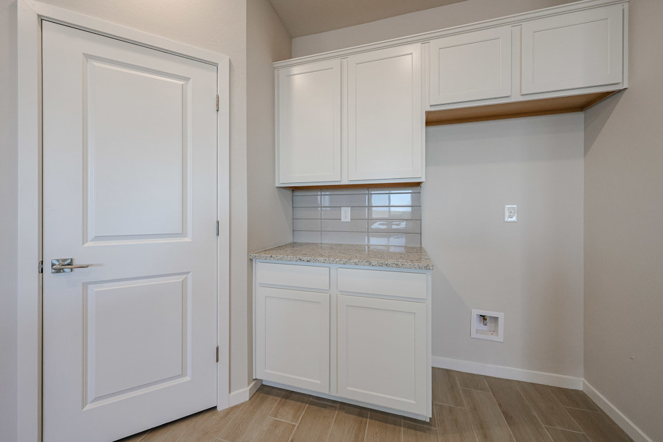 A kitchen with white cabinets.