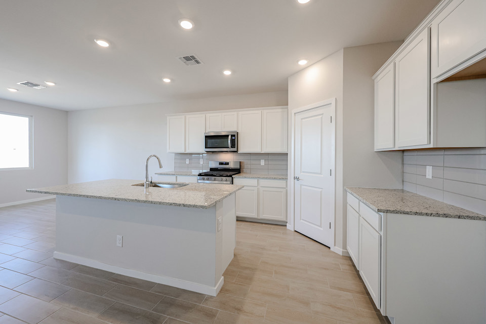 A kitchen with white cabinets.