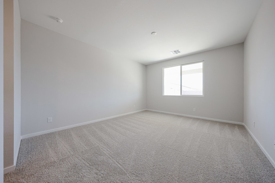 A room with a carpet and a window.