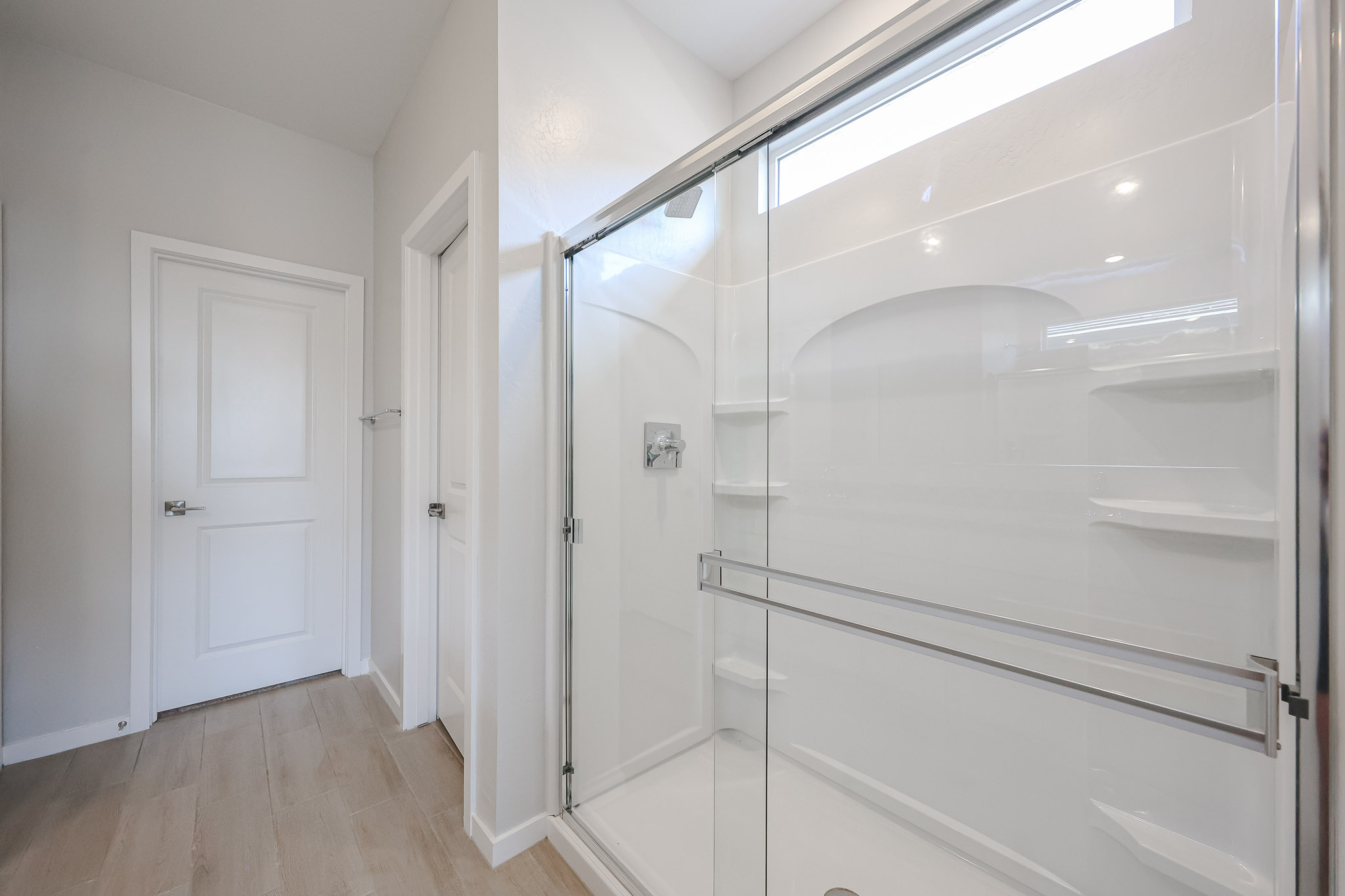 A white closet with glass doors.