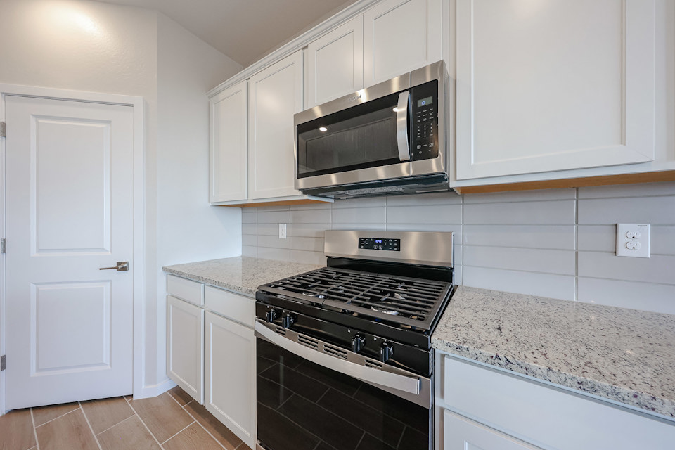 A kitchen with white cabinets.