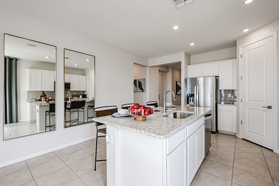A kitchen with white cabinets.