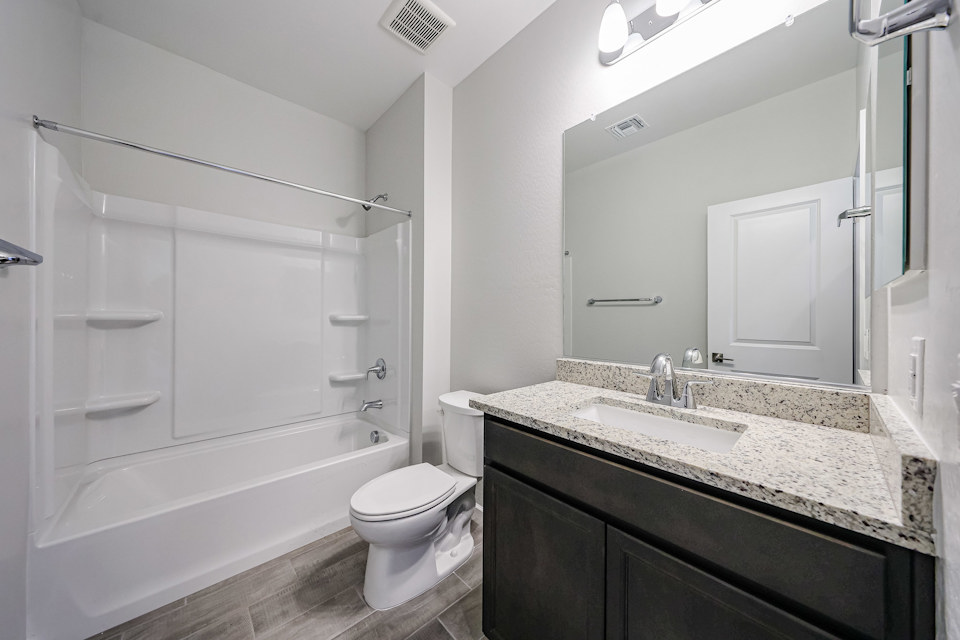 A bathroom with a tub sink and toilet.