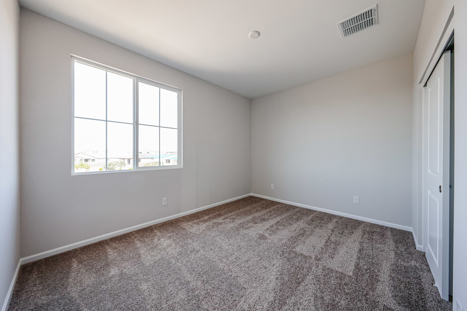 A room with a window and carpet.