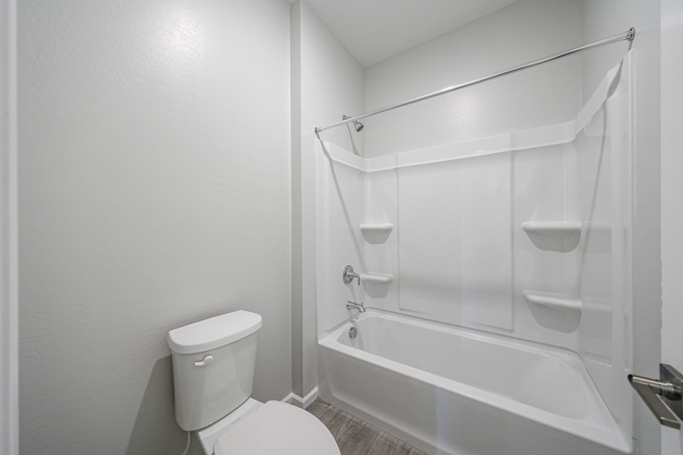 A bathroom with a shower and toilet.